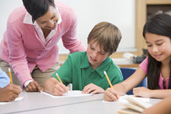 A few students working on an assignment with the assistance of a teacher